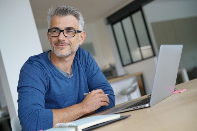 Middle-aged man working from home-office on laptop