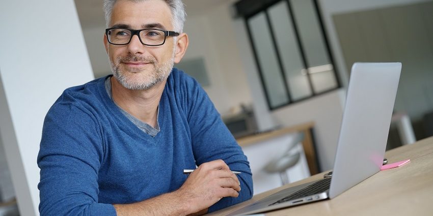 Middle-aged man working from home-office on laptop
